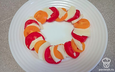 Нарежьте ломтиками моцареллу. Все кругом выложите на тарелку, чередуя моцареллу и помидоры.