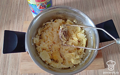 Когда картофель приготовится, станет мягким слейте всю воду. С помощью толкушки разомните картошку. Добавьте 1,5 стакана молока, снова хорошенько разомните.