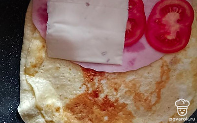 Обжарьте яйцо на небольшом огне. Переверните блюдо тортильей вниз. Выложите начинку в любой последовательности. 