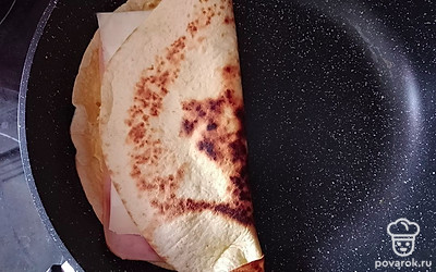 Сверните лепешку пополам. Держите с обеих сторон по несколько секунд, чтобы сыр растаял. 