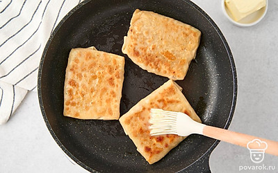 Переверните лепешку, смазывая ее маслом, еще 2-3 раза, пока она не обжарится до темно-золотистой корочки. Переложите лепешку на блюдо и жарьте таким же образом остальные лепешки.