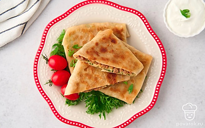 Подайте лепешки гезлеме с натуральным йогуртом, выложив на листья салата и украсив помидорами черри.