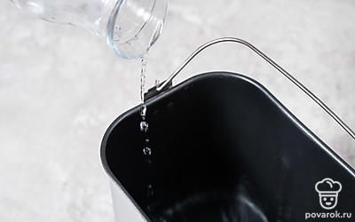 Достаньте контейнер для хлеба из хлебопечки. Влейте в него теплую воду.