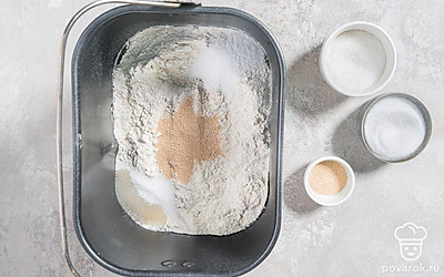 В один угол контейнера всыпьте соль, а в другой — сахар. По центру выложите сухие дрожжи.