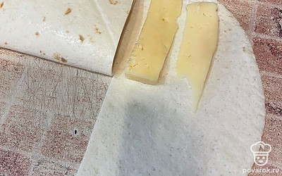 Складываем часть лепешки. На соседнюю сторону выкладываем сыр и снова складываем.