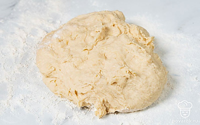 Взбейте венчиком в еще одной миске 1 куриное яйцо с сахаром и солью. В большую миску пересыпьте всю муку и сделайте по центру углубление. Добавьте в это углубление сухое молоко, взбитое яйцо, опару и мучную заварку. Вымешивайте тесто сначала деревянной ложкой. Потом выложите тесто на рабочую поверхность и месите его руками не меньше 15 минут.