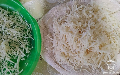 Натереть сыр на мелкой терке. Из теста сформировать шарик. Раскатать немного. На середину положить тертый сыр. Залепить края и раскатать скалкой.