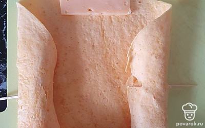 В края лепешки заворачиваем сыр и закалываем зубочисткой.