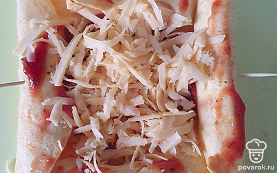 Внутри лепешку смазываем кетчупом, выкладываем сверху сыр.