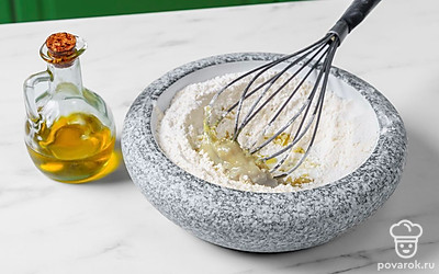 Добавьте в миску дрожжи и соль, а затем тщательно перемешайте сухие ингредиенты. Влейте в миску растительное масло. Подогрейте по отдельности воду и молоко до теплого состояния и влейте их в миску к ингредиентам. Тщательно перемешайте ложкой до однородной массы.