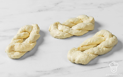 Готовое тесто разделите на 4 равные части. Каждую часть теста слепите в форме узелка. Для этого сверните тесто в длинную «веревку». Затем сделайте узелок, а края приблизьте к центру.