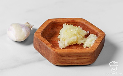 Чеснок пропустите через пресс или натрите на мелкой терке, а затем добавьте его к растопленному маслу.