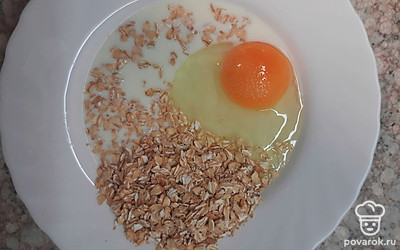 В глубокую чашку разбить яйцо, добавить к нему молоко, крупу и щепотку соли.