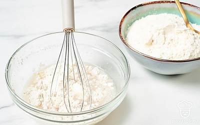 Когда на поверхности воды появятся пузырьки, начните постепенно всыпать в воду муку, постоянно размешивая.