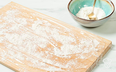  На доске закрепите пищевую пленку, слегка присыпьте ее мукой.