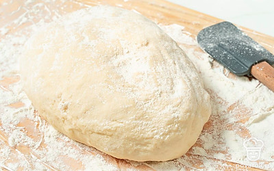 На поверхности теста очень тонким слоем распределите муку