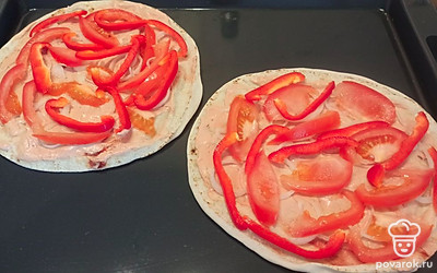 Смазываем питу приготовленным соусом. Сверху выкладываем нарезанные помидор, перец, лук. 