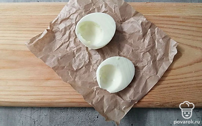 Куриные яйца предварительно отварите. Вареное яйцо очистите и разрежьте пополам, удалив желток. Он пригодится для начинки.