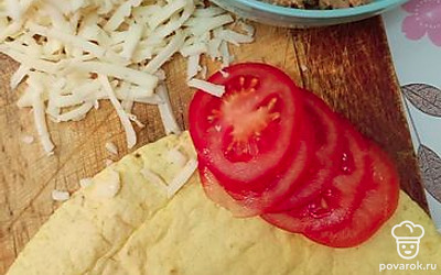 Сыр натираем на крупной терке, помидор нарезаем колечками. 