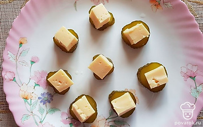 Сыр нарежьте небольшими кубиками, разложите поверх огурца. 
