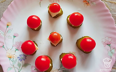 Помидоры черри помойте и разрежьте пополам. Положите на сыр. 