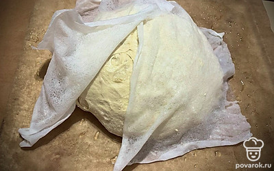 Снова обмять, сформировать шар. Уложить на противень, застеленный пергаментной бумагой и смазанной маслом. Накрыть полотенцем и оставить еще на 20 минут. 