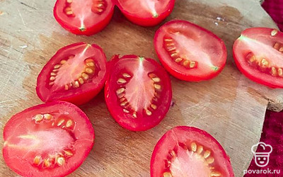 Помидоры промойте и разрежьте пополам.