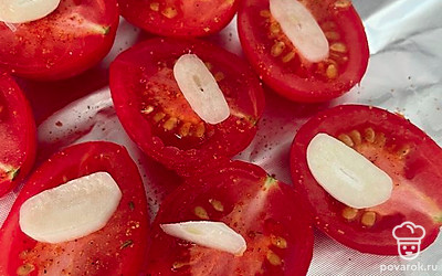 Выложите слайсы чеснока на помидоры. Сбрызните все оливковым маслом и запекайте в духовке 30 минут при 160 градусах.