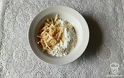 Добавьте 40 граммов тертого сыра к кабачку с мукой и яйцом. Хорошо перемешайте.