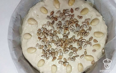 Смажьте поверхность теста растительным маслом. Посыпьте миндалью и семечками подсолнечника. Поместите хлеб в духовку на 40 минут при 200 градусах.