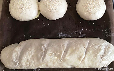 На батоне делаем небольшие поперечные надрезы. Смазываем все изделия сверху яичным желтком. Убираем противень в разогретую до 180 градусов духовку на 1 час. 