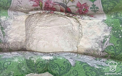 Стол обильно припыляем мукой, выкладываем тесто и делим на две части, складываем конвертиком и кладём на полотенце, посыпанное мукой, на расстойку минут на 15. 