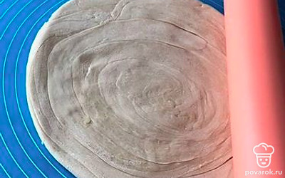 Тесто раскатайте в тонкий пласт. Чем тоньше тесто, тем лучше: лепешки получатся более хрустящими. Смажьте растительным маслом, заверните в рулет, а затем рулет в улитку. Раскатайте готовые лепешки.