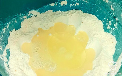 Влейте тёплую воду (примерно 40 градусов) и растительное масло. Замешивайте тесто минут 5.