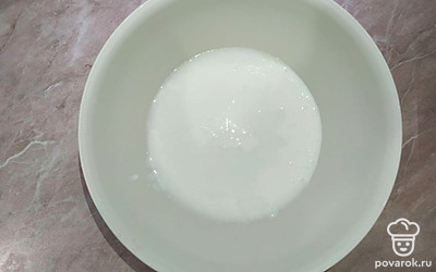 В глубокую миску налейте кефир и кипяток. Смесь должна получиться теплой. Добавьте соль и дрожжи и перемешайте.