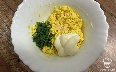 Добавьте измельченный укроп, майонез и натертый на мелкой терке чеснок. Тщательно перемешайте.