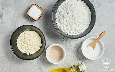 Два вида муки просейте через сито. Согрейте воду до 38-40 градусов. Возьмите два противня — обычный и с глубоким дном, а также пергаментную бумагу.