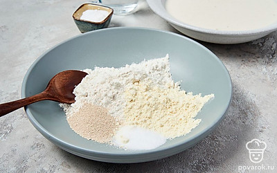 Приготовьте тесто. В миску всыпьте 250 г пшеничной муки, 40 г кукурузной муки, соль и дрожжи. Готовую смесь хорошо перемешайте. После этого добавьте теплую воду и подготовленную опару. Еще раз перемешайте ингредиенты, а после оставьте на 10 минут. Когда смесь настоится, добавьте к ней оставшуюся муку и масло, снова тщательно перемешайте. Глубокую емкость смажьте небольшим количеством масла и переложите в нее тесто. Оставьте его на 2-3 часа.