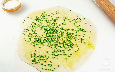 Вернемся к основе блюда. Раскатайте готовое тесто в тонкую лепешку. Хорошо смажьте ее топленым маслом. Добавьте измельченный зеленый лук и кунжут.