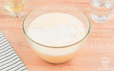 В глубокую миску разбейте три куриных яйца, влейте стакан воды и добавьте соль. Взбейте жидкость до момента появления пены. Затем добавьте просеянную муку и разрыхлитель. Замесите густое тесто для баурсаков.