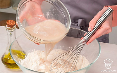 Замесите тесто. Выложите на ровную поверхность муку в виде горки с углублением в центре. В это углубление влейте четверть опары из дрожжей и, постоянно перемешивая, доливайте оставшуюся жидкость. Добавьте оливковое масло и вымесите упругое тесто, слепите из него шар, накройте полотенцем и оставьте на 60 минут.