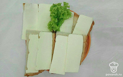 Подавайте кусочки домашнего свежего хлеба на небольшой тарелке, можно сразу со сливочным маслом. Порцию бутербродов украсьте листьями салата.