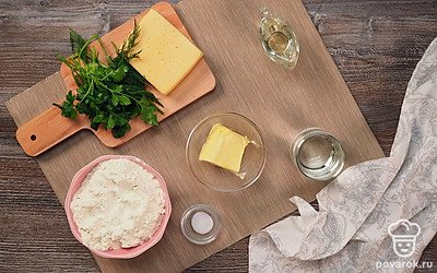 Подогрейте воду в чайнике или в микроволновой печи, чтобы она стала теплой. Просейте муку через сито. Сыр натрите на крупной терке. Зелень промойте под проточной водой и порубите ножом. Также ее можно измельчить в блендере.