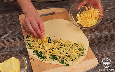 Раскатайте лепешки. Так как тесто податливое, его можно растянуть руками и сделать лист очень тонким. Диаметр должен соответствовать диаметру сковороды. На одну половину лепешки выложите зелень и сыр. Накройте второй половиной, слепите края, тщательно защипывая.