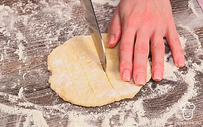 Раскатайте тесто в колбаску и поделите ее на 8 равных частей. Каждую часть раскатайте в лепешку толщиной 0,5 см. Сделайте небольшие надрезы в лепешках.