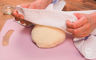 Начните готовить тесто для лепешек на кипятке и муке с манкой. Для этого возьмите миску с мукой и манной крупой, добавьте соль, сахар и дрожжи. Перемешайте сухие ингредиенты ложкой. После этого влейте воду. Делать это нужно тонкой струйкой, размешивая смесь ложкой. Когда тесто будет более плотным, а вода впитается, замесите его руками 5-8 минут. Накройте тесто полотенцем и поставьте около батареи или в другом теплом месте. Оно должно подняться.