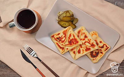 Для подачи вам понадобятся соленые огурцы. Нарежьте их колечками и выложите рядом с лепешкой на тарелке.