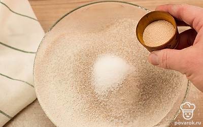 Просейте обе муки в большую миску. Добавьте соль, сахар, дрожжи и хорошо перемешайте.