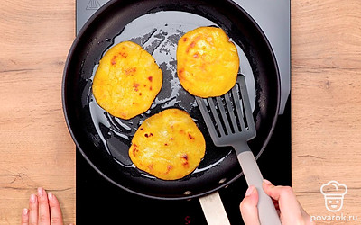 Обжарьте лепешки. В сковороде разогрейте растительное масло. Выложите подготовленные кукурузные заготовки и жарьте лепешки на среднем огне около 5 минут до золотистой корочки. Затем лепешки переверните и жарьте с другой стороны еще около 5 минут.