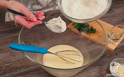 Начните готовить тесто для лепешек с сыром на молоке. Возьмите сухую чистую емкость большого размера и разбейте туда яйцо. Добавьте молоко и перемешайте. После этого возьмите половину муки и введите ее в жидкую смесь небольшими порциями. Размешайте до однородности.